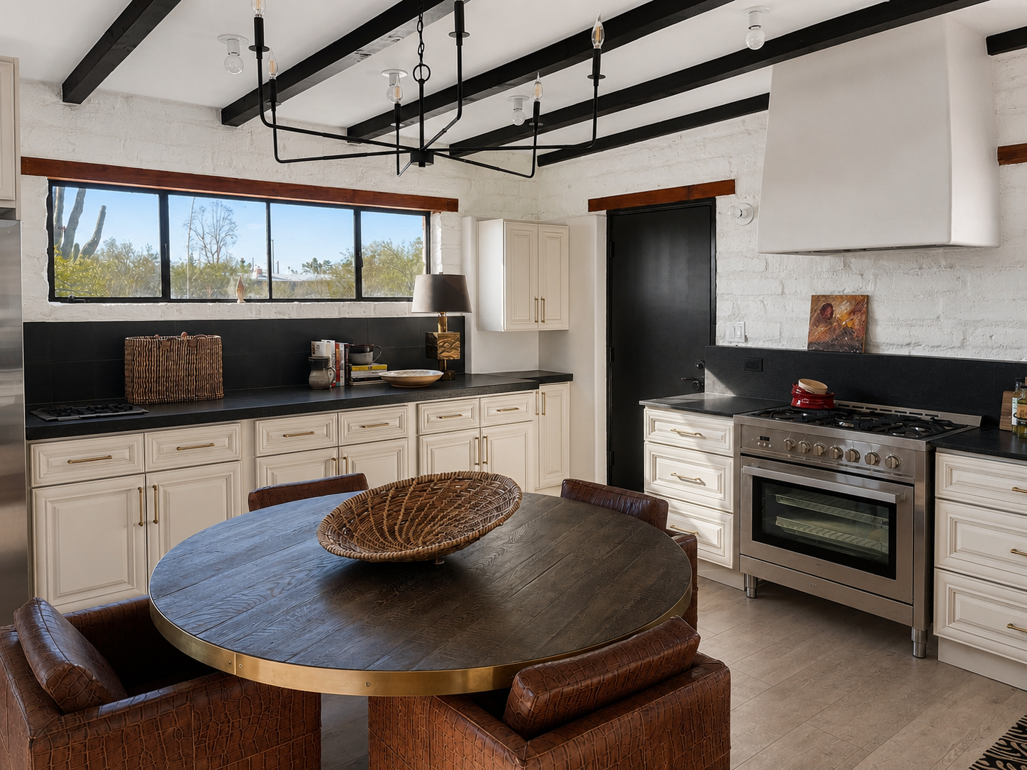 San Carlos kitchen with black ceiling beams, cream cabinetry and a round wood dining table